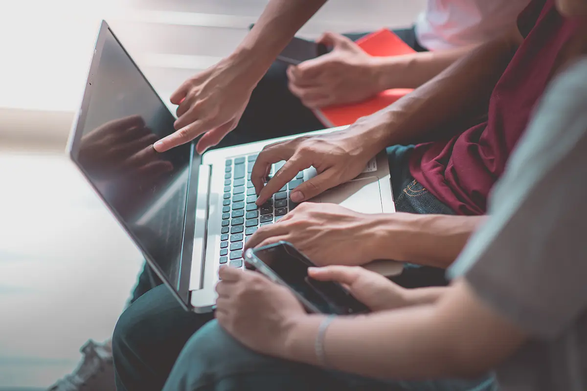 barrierefreiheitsgesetz - Umsetzungshilfen Eine Gruppe von Menschen sitzt zusammen und schaut in einen Laptop